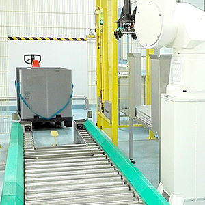 A picture of an empty stainless-steel roller conveyor for pallet size plastic containers